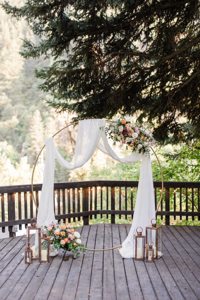 Pretty circular arch with rich greens and colorful flowers. Lush Mountain Wedding